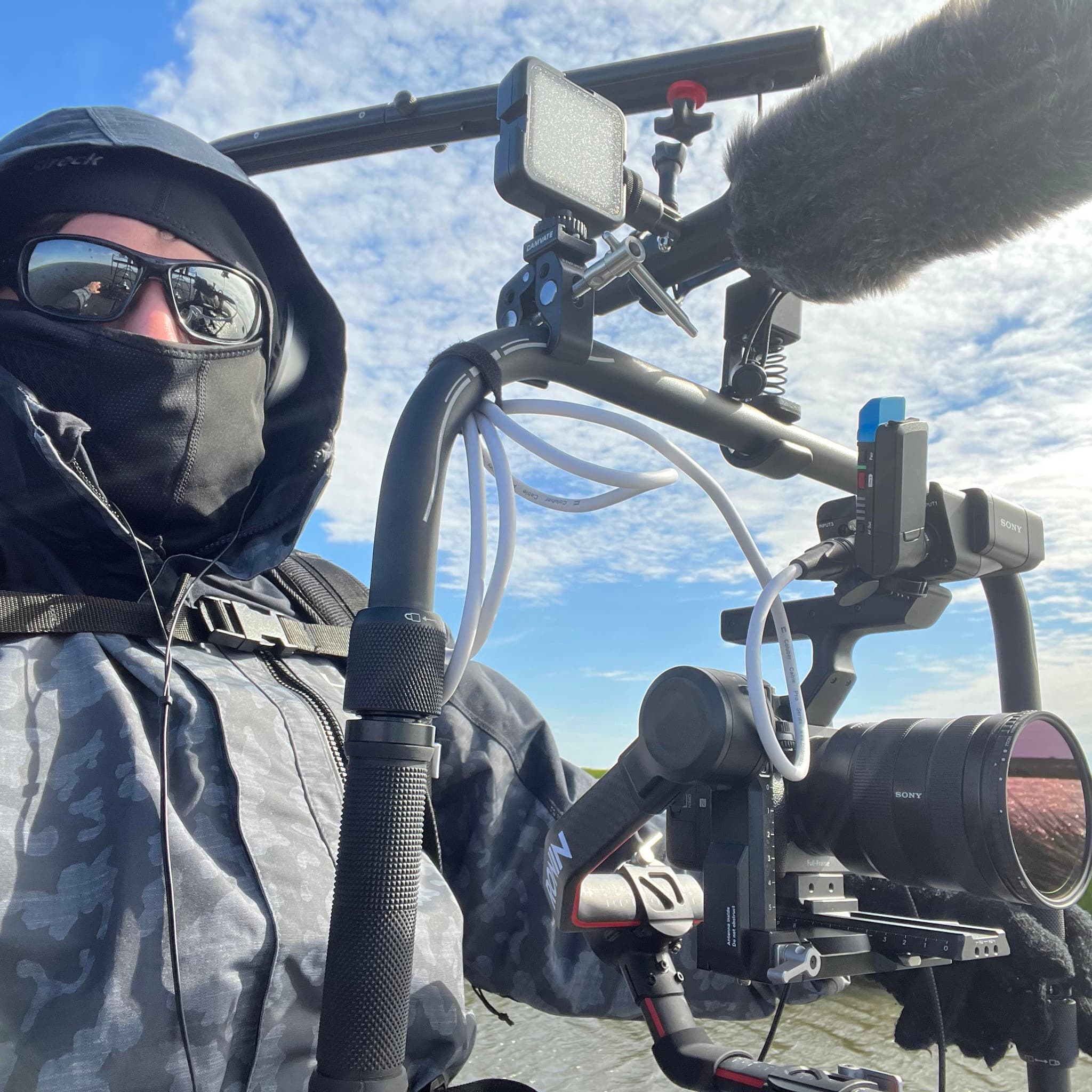 Wes filming on location with a Sony camera, stabilizer, and microphone.